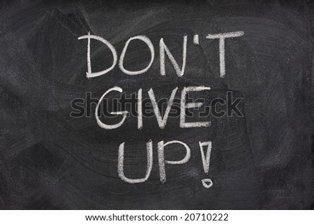 motivational phrase, don\'t give up, handwritten with white chalk on a blackboard