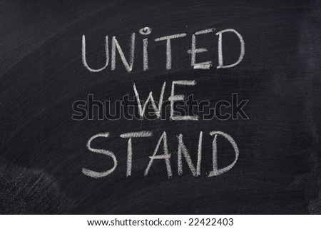 united we stand phrase handwritten with white chalk on blackboard