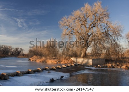 dam on the Cache la Poudre River diverting water into Evans Ditch for farmland irrigation in Colorado, winter scenery