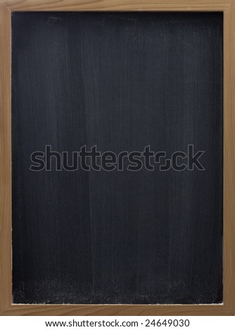 blank blackboard in wooden frame, white chalk eraser smudges