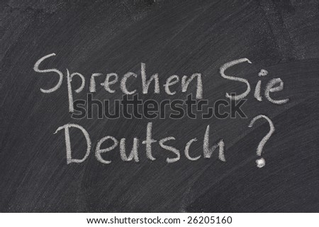 Sprechen Sie Deutsch? Do you speak German question handwritten with white chalk on a blackboard with eraser smudges