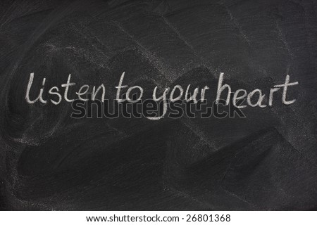 listen to your heart phrase handwritten with white chalk on a blackboard with eraser smudge patterns