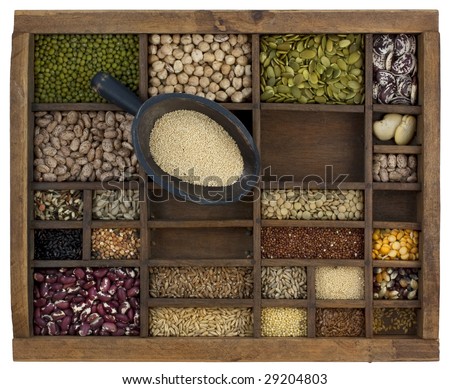 rustic scoop of amaranth grain and a variety of beans, lentils, seeds in old wooden typesetter case, isolated with clipping path