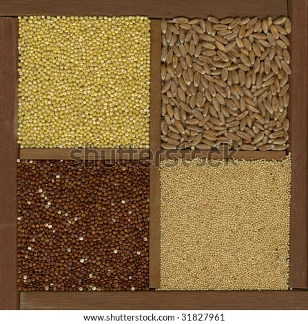 four ancient cereal grains - millet, spelt, amaranth, red quinoa in a wooden box or drawer with dividers