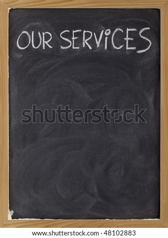 our services - white chalk handwriting on blackboard with eraser smudges, copy space below