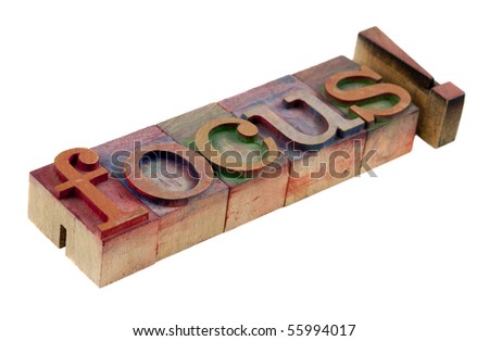 the word focus with exclamation point in vintage wooden letterpress type blocks, stained by color ink, isolated on white