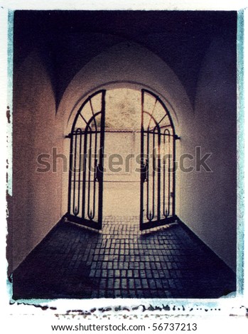corridor and iron gate in old building leading to light, instant photo image transfer on watercolor paper, rough texture