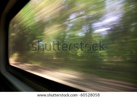 green trees - a blurred window view from a train in motion