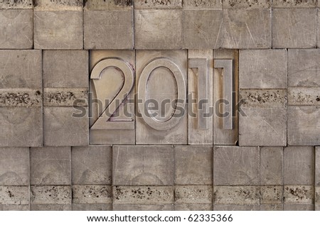 New Year of 2011 - numbers in vintage scratched metal letterpress printing blocks, wall background
