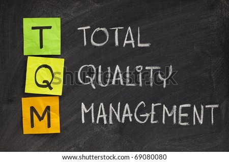 TQM acronym (total quality management) - white chalk handwriting and sticky notes on blackboard