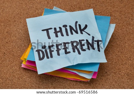 think different concept - motivational phrase on a stack of sticky notes against cork bulletin board
