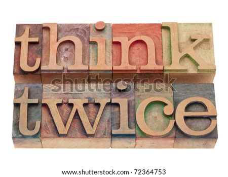 think twice phrase in vintage wood letterpress printing blocks, stained by color inks, isolated on white