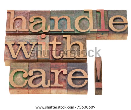 handle with care warning in vintage wood letterpress printing blocks, isolated on white