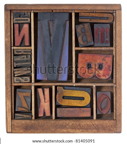 a variety of vintage letterpress printing blocks with big letter V in a small wooden typesetter box with dividers, isolated on white