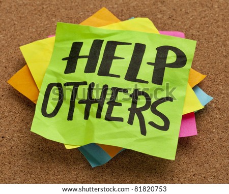 help others reminder on sticky note posted on a cork board