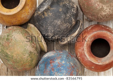 clay pots (planters) with a color grunge finish on wooden surface