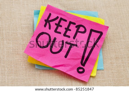 Keep out warning  - handwriting on a purple sticky note against canvas board