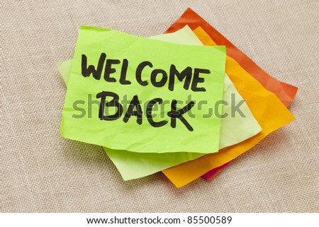 welcome back - handwriting on a green sticky note against canvas board