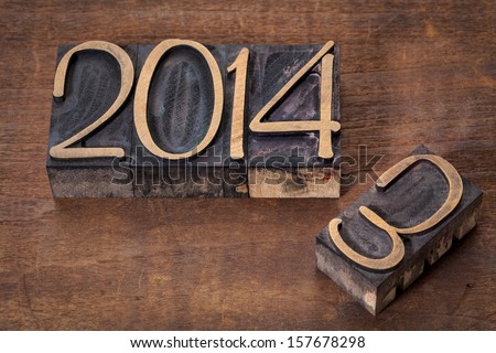 new year 2014 replacing old year 2013 - letterpress wood type on a grunge wooden surface