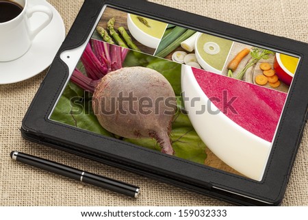 reviewing pictures and recipe for vegetable cream soup on a digital tablet