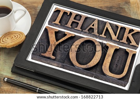 thank you  - text in vintage letterpress wood type on a digital tablet with coffee
