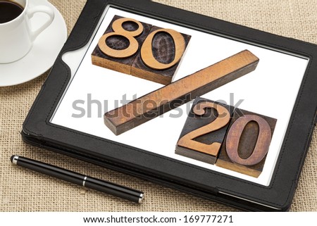 Pareto principle or eighty-twenty rule represented in wood letterpress printing blocks on a digital tablet screen