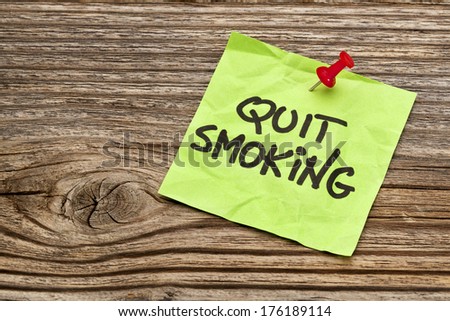 quit smoking reminder note against grained weathered wood