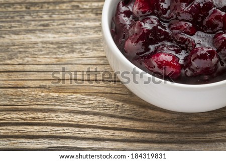 sugar free cranberry sauce with addition of blueberry - side dish bowl against grained wood