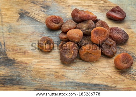 a pile of sun dried Turkish apricots on grunge painted wood surface