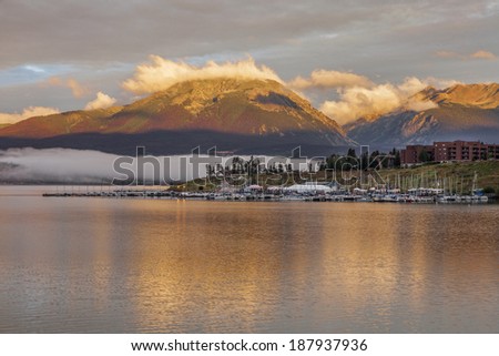 foggy sunrise over Lake Dillon and marina in Colorado with a mountain forest damaged by pine beetle