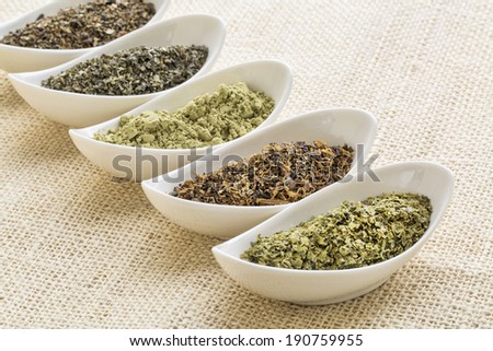 bowls of seaweed diet supplements (bladderwrack, sea lettuce, kelp, wakame and Irish moss) on burlap canvas