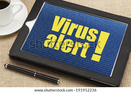 virus alert on a digital tablet with a cup of coffee