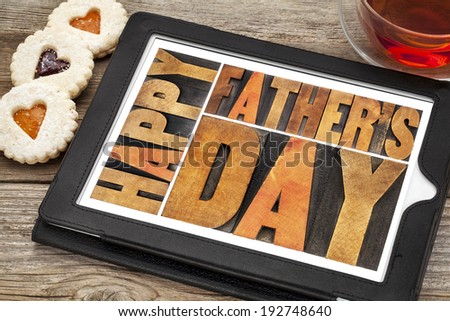 happy father\'s day - a word abstract in antique wood letterpress printing blocks on a digital tablet with heart biscuit cookies