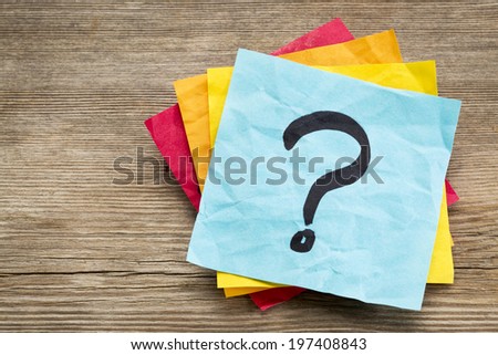 question mark on a sticky note against grained wood