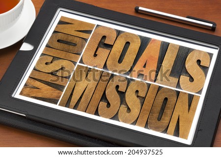 goals, vision and mission - a collage of isolated words in letterpress wood type on a digital tablet with cup of tea