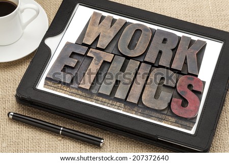 work ethics in vintage letterpress wood type on a digital tablet with a cup of coffee