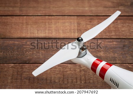 flexible, plastic propeller of a small drone (quadcopter) against red barn wood