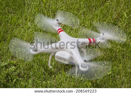 FORT COLLINS, CO, USA, AUGUST 1 2014:  Radio controlled DJI Phantom quadcopter drone taking off from a grass field