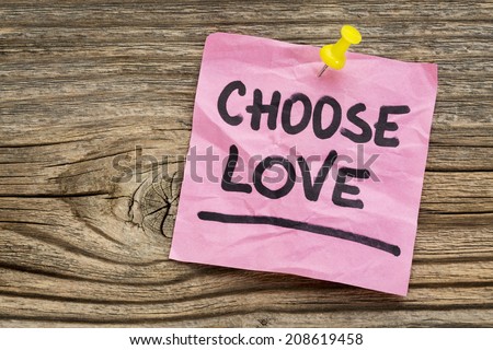 choose love reminder - handwriting on a green sticky note against grained and knotted wood board