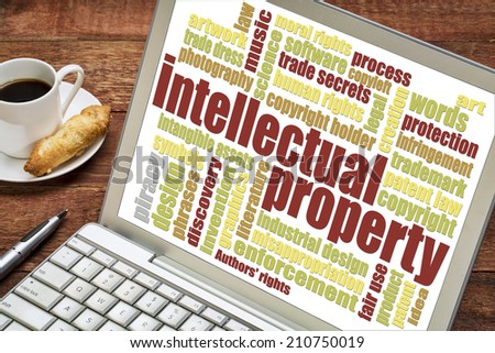 intellectual property word cloud on digital tablet with a cup of coffee