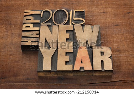 Happy New Year 2015 greetings - text in vintage letterpress wood type blocks on a grunge wooden background