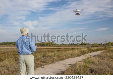 FORT COLLINS, CO, SEPTEMBER 28, 2014:  Photogrpaher, Marek Uliasz, is lflying the DJI Phantom 2 quadcopter drone with Panasonic Lumix GM1 camera on board over a marsh natural area.