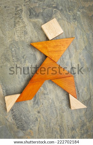 abstract of a dancing, running or walking figure built from seven puzzle wooden pieces,, the artwork copyright by the photographer