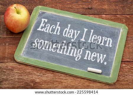 Each day I learn something new - positive words on a slate blackboard against red barn wood