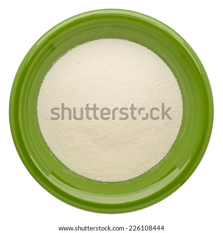 collagen protein powder on an isolated green ceramic bowl, top view