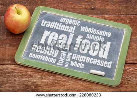 real food word cloud on a blackboard with an apple - healthy lifestyle concept