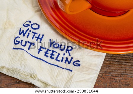 go with your gut feeling - advice or motivational reminder  on a napkin with cup of coffee