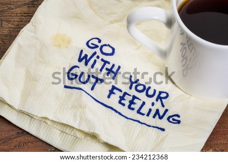 go with your gut feeling - advice or motivational reminder  on a napkin with cup of espresso coffee