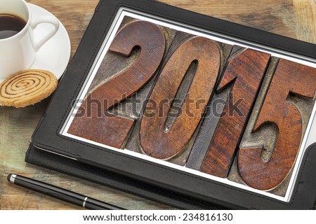 2015  - New Year concept  - isolated text in vintage wood type printing blocks on a digital tablet with a cup of coffee