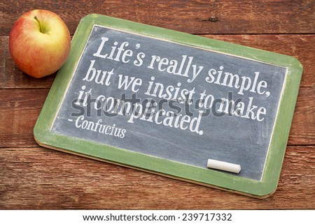 Life is really simply, but we insist to complicate it - a wisdom quote by Confucius on a slate blackboard against red barn wood